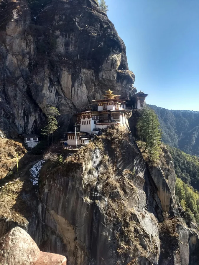 Bhutan hillside monastery with prayer flags against Himalayan backdrop
