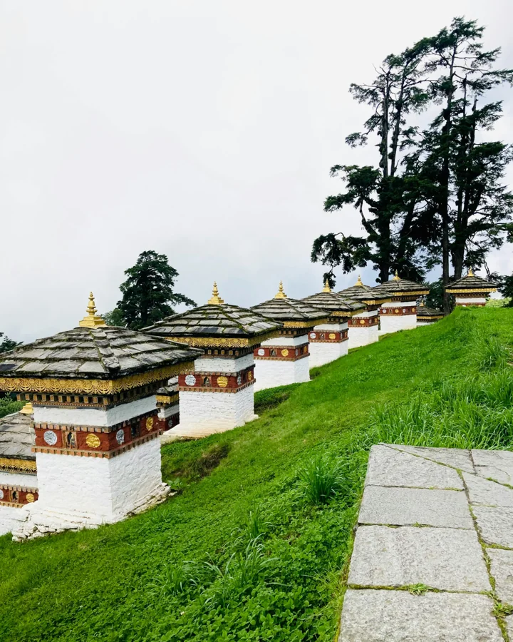 Bhutan hillside monastery with prayer flags against Himalayan backdrop