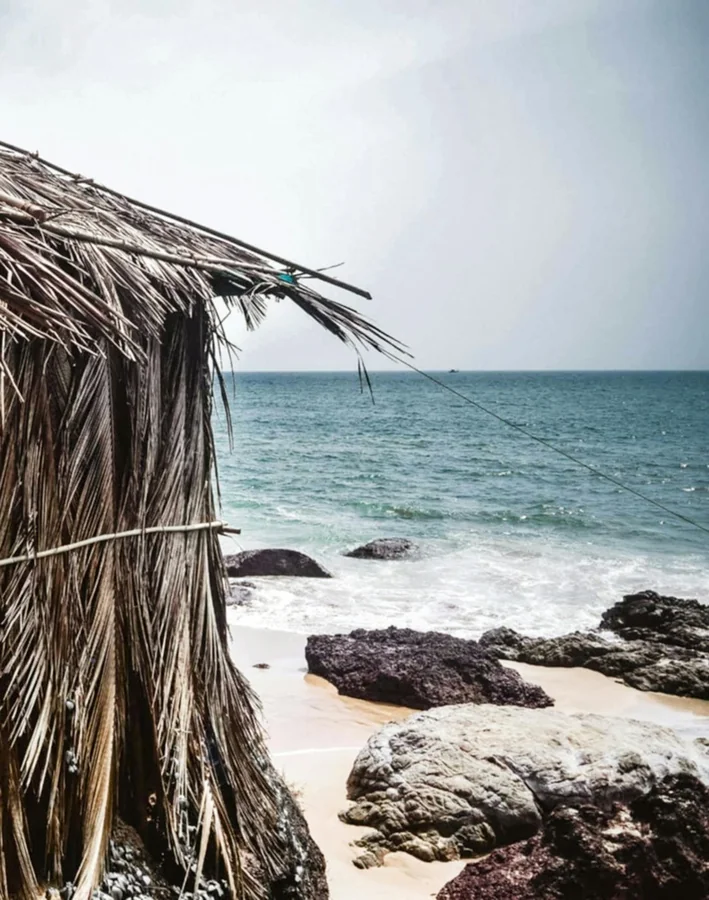 Goa beach with palm trees and colorful beach shacks by the Arabian Sea