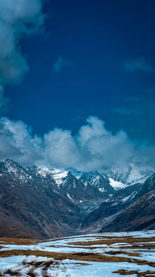 Scenic mountain valley in Himachal Pradesh with pine forests and snow peaks